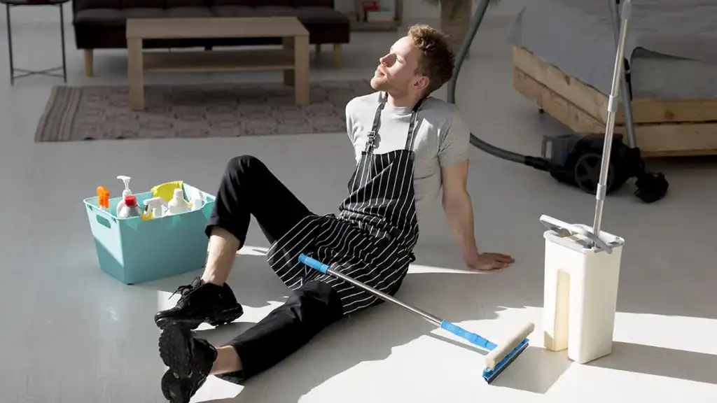 Exhausted housekeeper mopping a floor, illustrating the risk of a missed clean going unnoticed - Zeevou