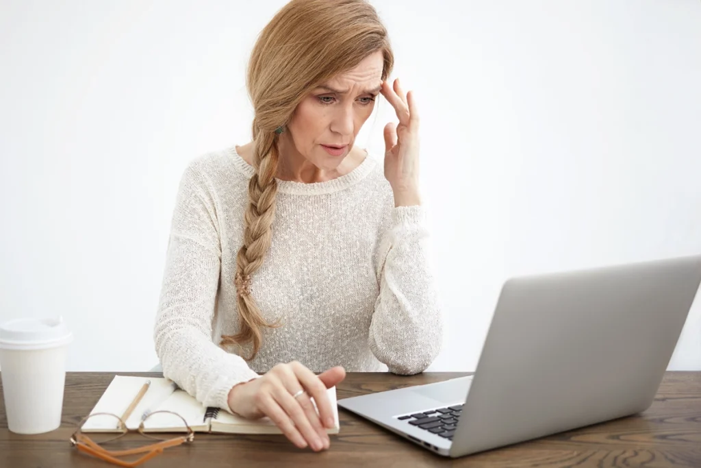 Property manager reacting to an unexpected payment failure alert on her laptop - Zeevou